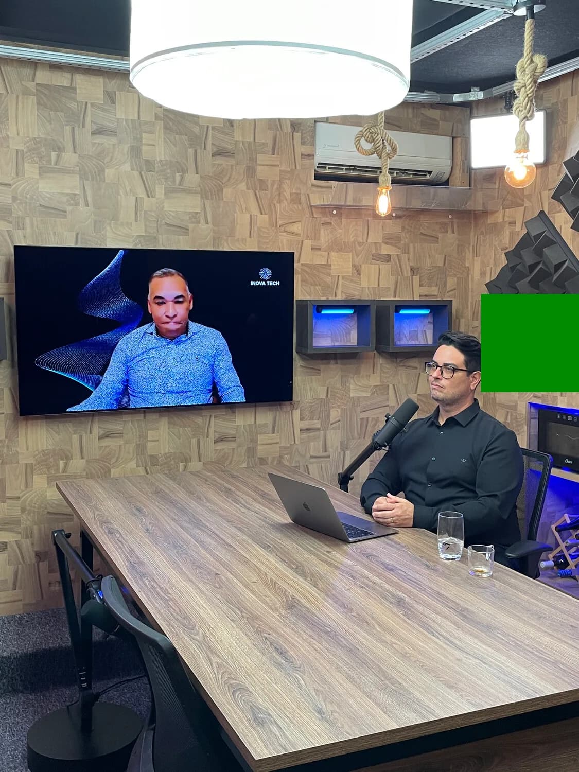 Joás Andrade na tela do estúdio, entrevistador em primeiro plano de costas